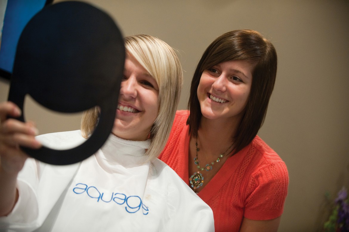 Sarah Lederman (right) checks her work after cutting sophomore Kalen Boshart’s (Wayland, Iowa) hair at Studio 400 in Hesston.