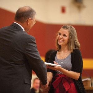Kayci Detweiler of Kokomo, Ind., receives her Hesston College diploma from President Howard Keim at the college’s centennial commencement.