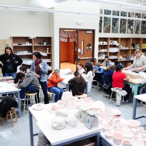 Marshall students design clay tiles on one of their tour stops. Hesston College art students and faculty will glaze and fire the tiles and incorporate them into a mosaic for the middle school.