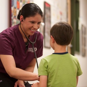 2016 Hesston College Nursing graduate Dra Aguilar (Wichita, Kan.) practices nursing skills on a young patient in this photo from 2015.