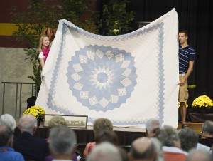 Jessie Couch ’07, Mulvane, Kan., and sophomore Chad Newcomer, Mount Joy, Pa., display a quilt for auction bidders.