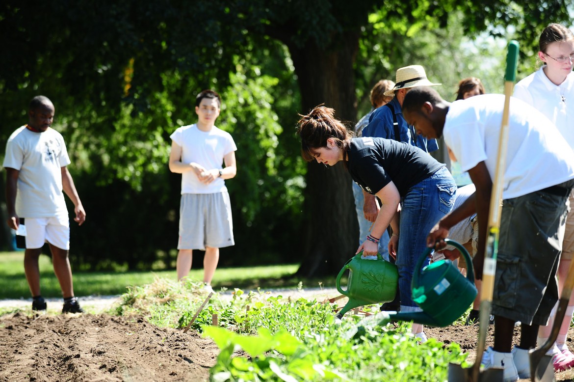 Dulaney Arzola of Stafford, Kan., and other students in the First Year Experience seminar work in the Intergenerational Community Garden.