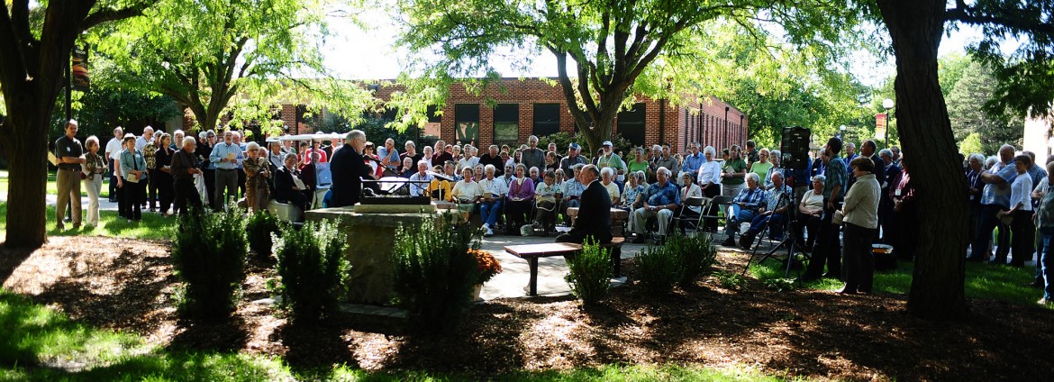 A crowd gathers to dedicate the Freedley Schrock memorial at Hesston College