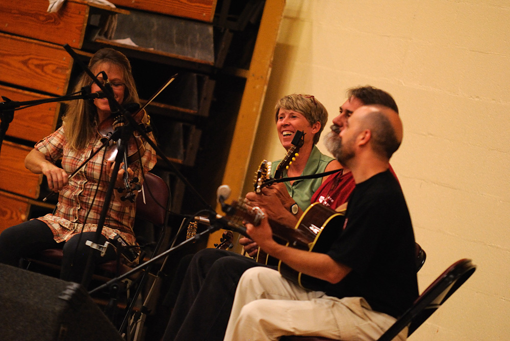 Gretchen Priest May, Dave Firestine and Tim May play live bluegrass music for the contra dance. Faculty member Jen LeFevre (second from left) was the caller for the evening.