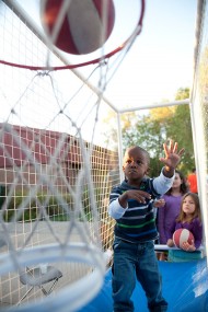 Caleb Enns, son of David ’01 and Ashley (Claassen) ’01 Enns, practices his shot during the Tailgate Picnic and Family Festival as his sisters Alia and Sara look on.