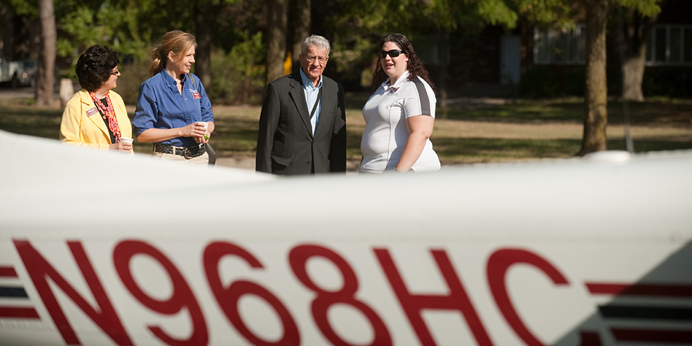 Amy Birdsell (right) talks with (from left) Dr. Sandra Zerger, vice president of Academics; Sandy Toews, Aviation staff; and former President Laban Peachey during Homecoming 2011.