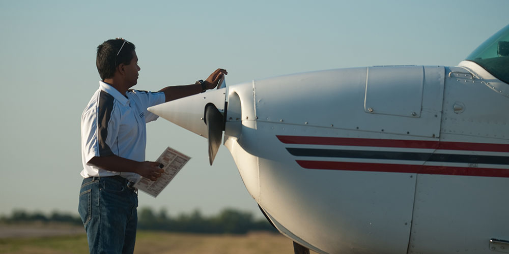 Hesston College sophomore Kush Lengacher prepares a plane for flight.