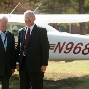 Former President Laban Peachey (1968 to 1980) and President Howard Keim pose with the Hesston College airplane with the radio call numbers in honor of President Peachey.