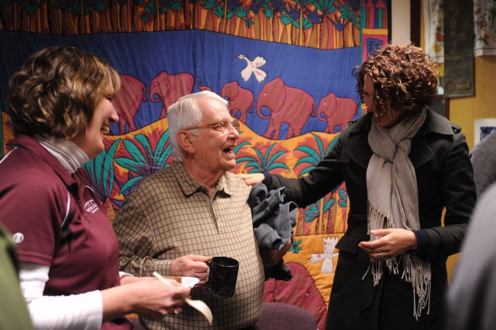 Bill Mason (center), longtime Hesston College employee, is congratulated by Melissa Unruh (left) and Rachel Swartzendruber Miller (right) during Mason’s retirement celebration at Hesston College Feb. 16.