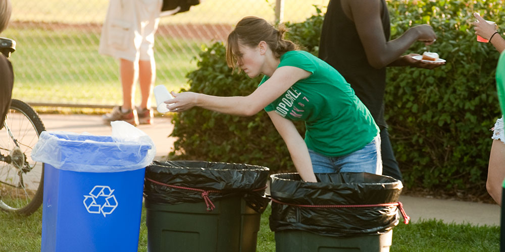 Hesston College sophomore Leah Mueller of Halstead, Kan., separates recyclables from trash during the college’s September 2011 homecoming celebration.