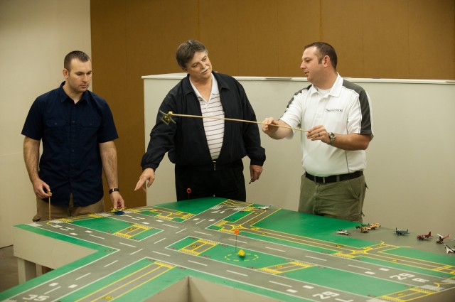 ATC lab_9371 Jerry Holloman (left) and Jacob Gayer (right), members of Hesston College's first class of Air Traffic Control graduates in May 2011, work with Director of Aviation Dan Miller in the on-campus table model simulation lab.