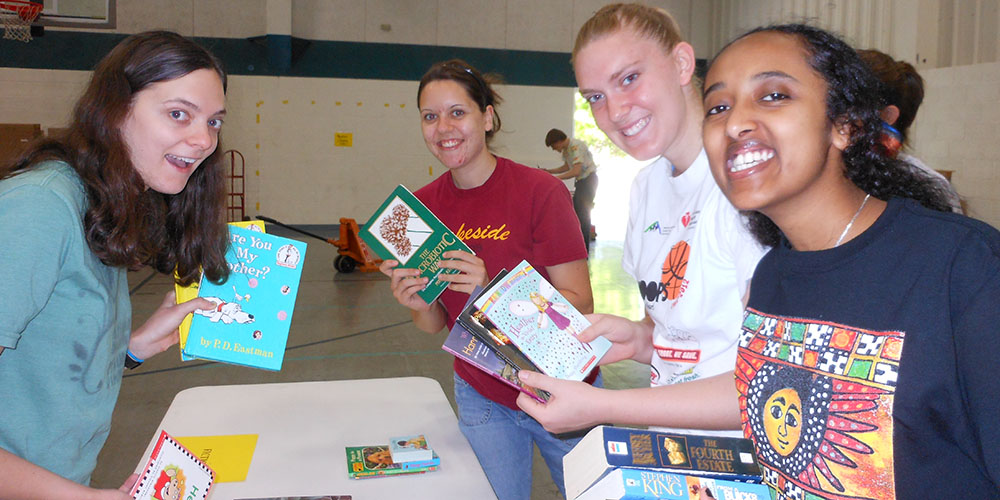 Hesston College students (from left) Evette Yoder (Phoenix, Ariz.), Anna Yoder (Garden City, Mo.), Carly Unruh (Wayland, Iowa) and Asbel Assefa (Addis Ababa, Ethiopia) package books for Ethiopia Reads during the campus packaging event sponsored by the African Student Union. Photo by Kendra Litwiller.