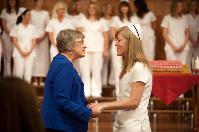 Erica Fitzmorris (Littleton, Colo.) receives a blessing from Hesston College nursing faculty member Sondra Leatherman during the nurses pinning ceremony.