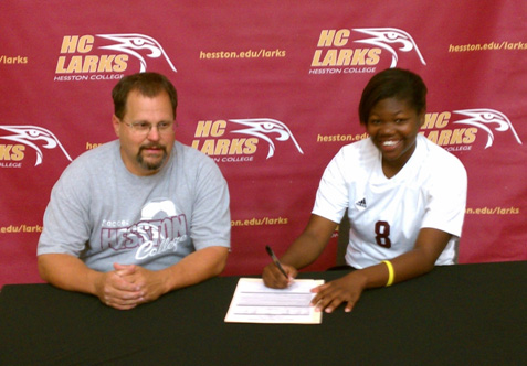 Amanda Balogun signs her letter of intent to play soccer at Hesston College for coach Bryan Kehr.