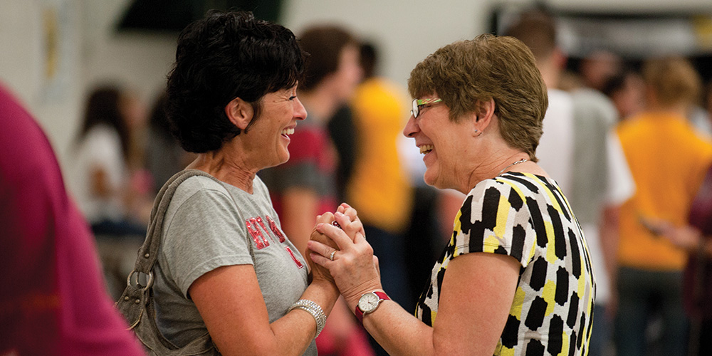 Sue (Eicher) ’73 Roth and Priscilla (Wyse) ’72 Clemens greet each other at the tailgate barbecue picnic and family festival Friday.