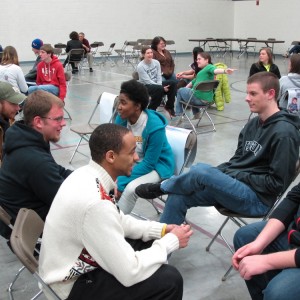 Hesston College students work together in a “family” group to plan out their strategy for the week during a poverty simulation led by Harvey County Circles of Hope.
