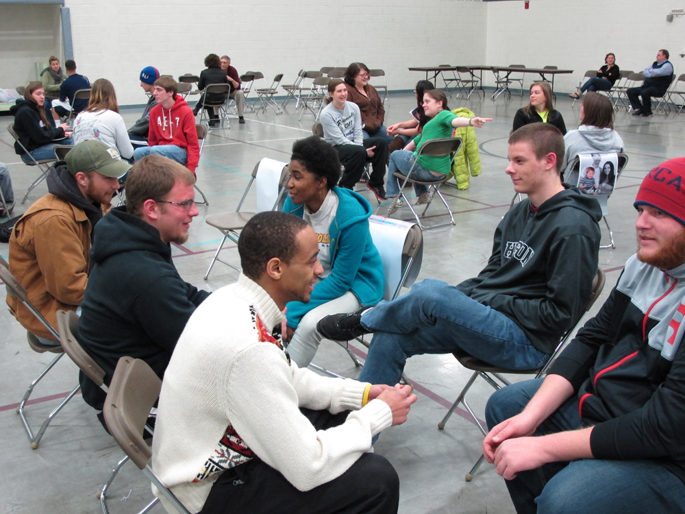 Hesston College students work together in a “family” group to plan out their strategy for the week during a poverty simulation led by Harvey County Circles of Hope.