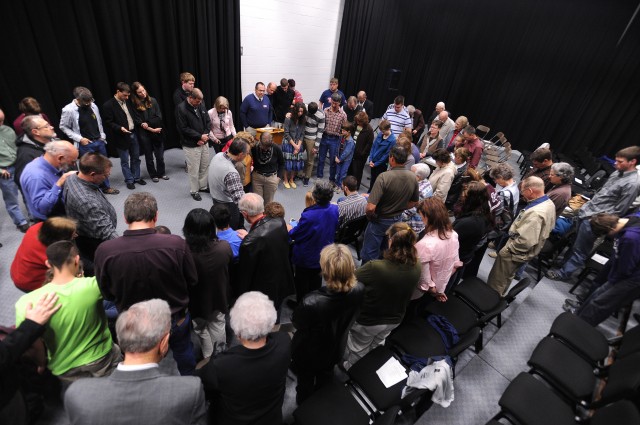 Faculty, staff, students and families surround disaster management graduates for a prayer of blessing following a recognition ceremony May 4.