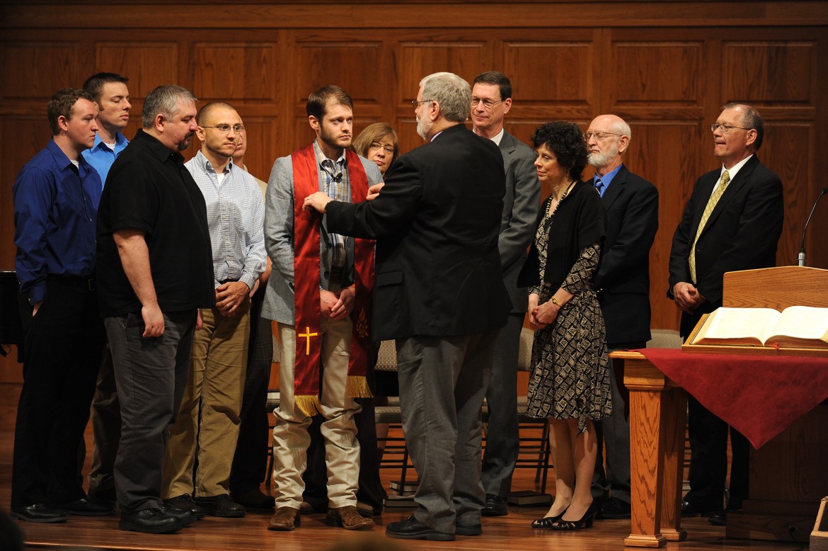 Pastoral ministries graduate Kenzie Intemann, Bessie, Okla., receives his stole and a blessing from program director Tim Lichti.