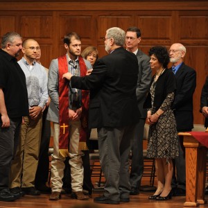 Pastoral ministries graduate Kenzie Intemann, Bessie, Okla., receives his stole and a blessing from program director Tim Lichti.