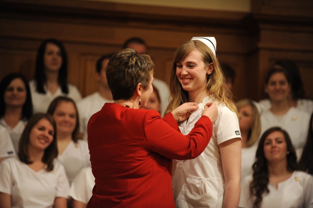 Nursing graduate Michaela Zook, Hesston, Kan., receives her pin from her mother and former nursing faculty member Marcella Zook.