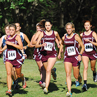 Hesston College women's cross country runs start a race.