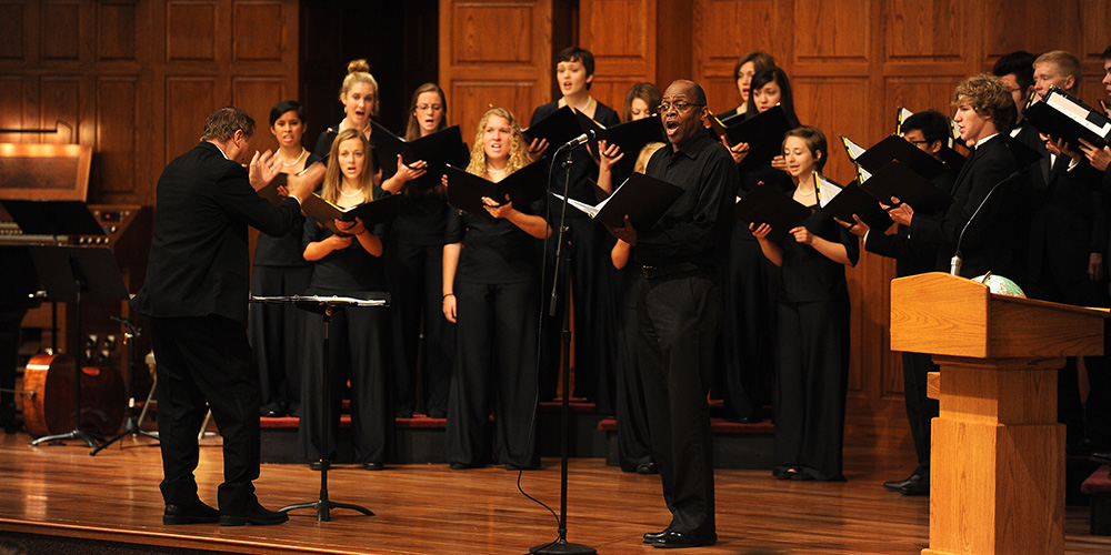 Hesston College sociology instructor and artist in residence Tony Brown joins the Hesston College Bel Canto Singers, under the direction of Bradley Kauffman, for a song during the college’s Opening Celebration service Aug. 16.