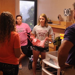 Hesston College freshmen Skylar Tripp and Kambree Carter and their parents talk with their resident assistant, Hayley Goevert, Hesston, Kan., as they move into the dorms Aug. 12.