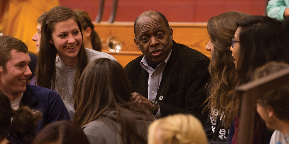 Tony Brown visits with students at a Hesston College basketball game.