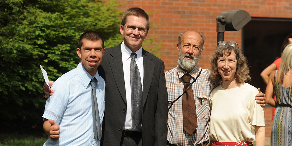 Simon Zehr (left) celebrates his graduation with his academic advisor Russ Gaeddert (second from left) and his parents Dennis Zehr and Ellen Davis-Zehr.