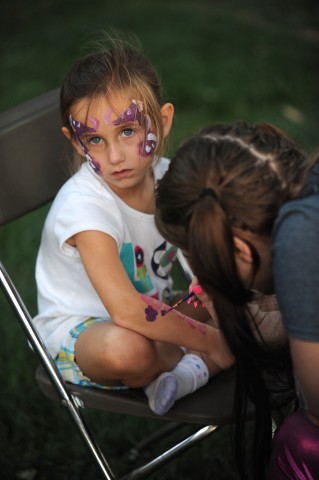 A young guest at the Friday evening Family Festival has her face and arms painted.