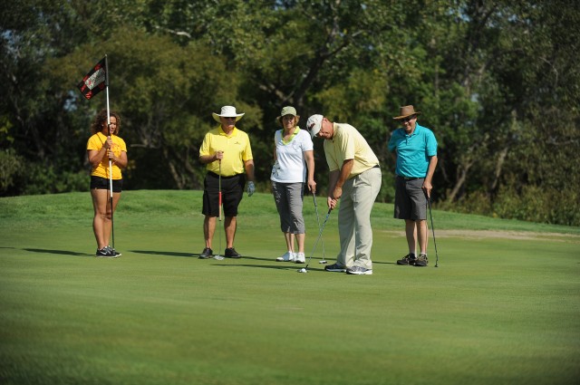 Hesston College President Howard Keim lines up putt during the Hesston College Benefit for Student Scholarships Sept. 25. Also pictured from left are Hesston College student caddy Kasee Tully (McPherson, Kan.), Excel Industries President Paul Mullet, Kansas State Senator Carolyn McGinn and Phil Osborne (Evanston, Ill.).