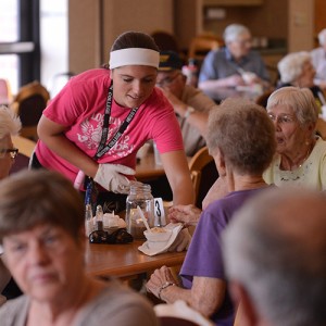 Hesston College freshman Brooke Hammond (Long Island, Kan.) serves ice cream to Schowalter Villa residents.