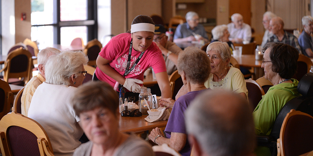 Hesston College freshman Brooke Hammond (Long Island, Kan.) serves ice cream to Schowalter Villa residents.