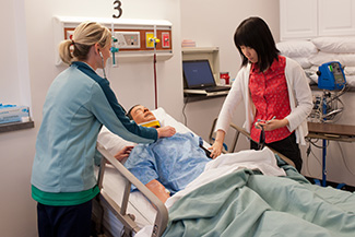 Former nursing students practice on a simulated patient in the on-campus Newton Medical Center nursing simulation lab.