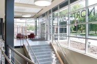 The front entry of the Northlawn Center for Performing Arts Education is an addition to the existing building, providing a welcoming entrance and access to the lower level. The glass front lets natural light into the building and offers an expansive view of campus.