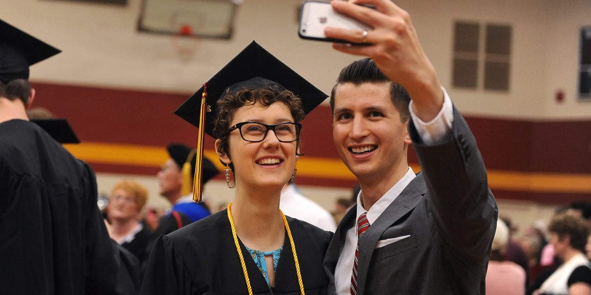 Graduate RaeLee Hightower (Tulsa, Okla.) takes a post-graduation selfie with English faculty member Donovan Tann.