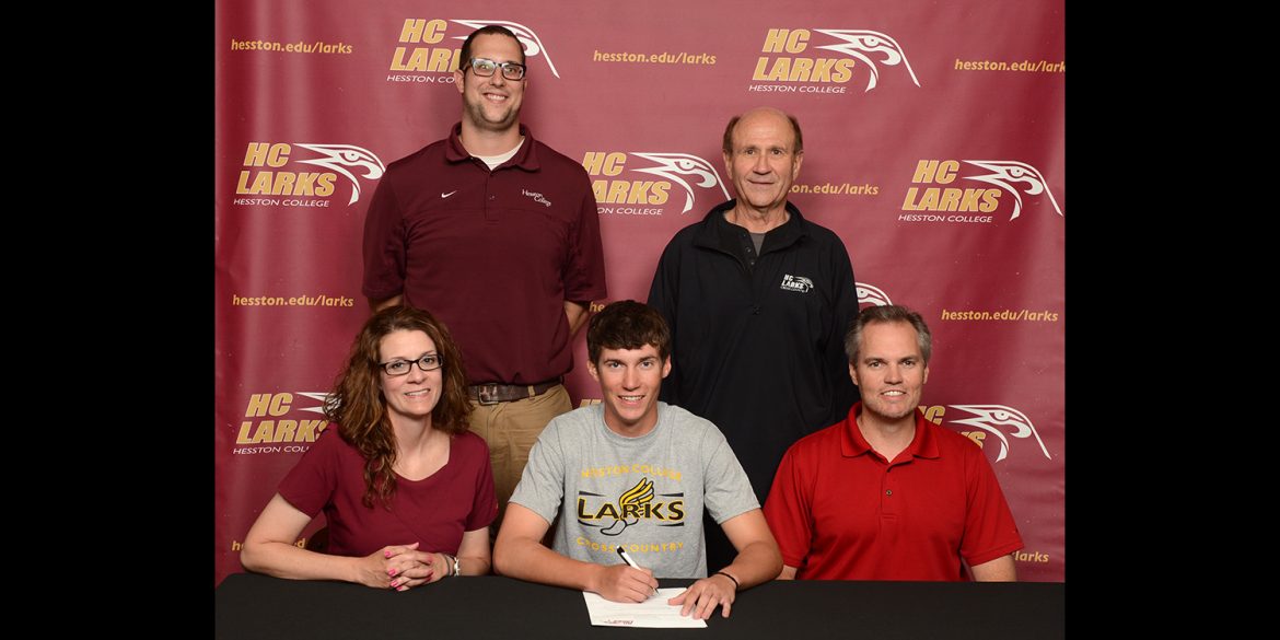Kyle Stucky signs a letter of intent to run cross country for Hesston College.