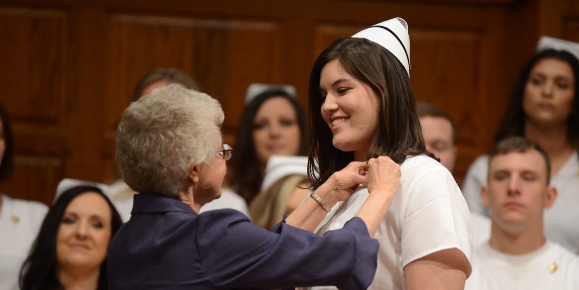 Emma Lindner receives her Hesston College nursing pin from instructor Joyce Huber.