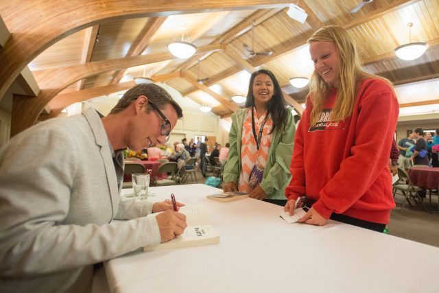 Joshua Davis autographs his book for Hesston College students.