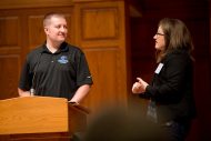 Dr. Kate Wiebe interviews Adam Miller (Hesston), a survivor the the shooting at Excel, during the opening AVDS session.