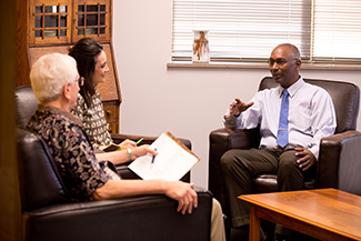 Joe talks with international admissions counselors Dave Osborne Ac64, ’66 and Mari Sailors during a March visit to campus.