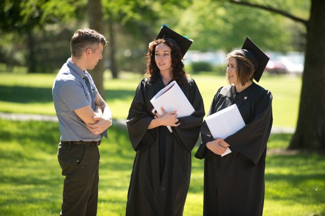 Nursing instructor Duane Miller visits with two of the college's first bachelor of science in nursing graduates, Kristen Rimer (Wichita, Kan.) and Alma Luevano (Wichita, Kan.).