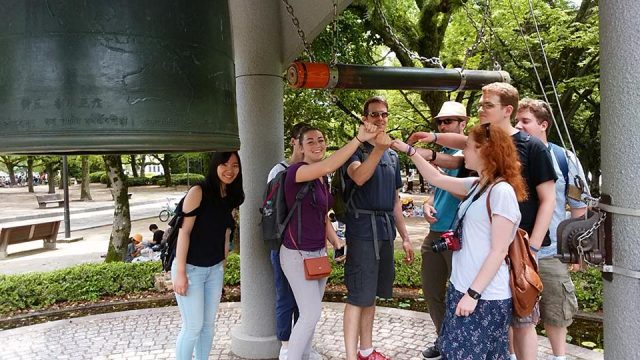 Participants on the May Term Japan trip ring the Hiroshima Peace Bell.