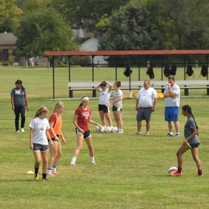 Hesston College women's soccer players demonstrate drills at a clinic for prospective Special Olympics coaches.
