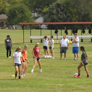 Hesston College women's soccer players demonstrate drills at a clinic for prospective Special Olympics coaches.
