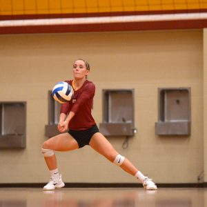 Hesston College volleyball action photo - Kylie Brenneman digs in a match with Cloud County CC, Oct. 6, 2017