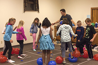 Sophomore Preston Judd organizes a group of children for a game at Whitestone Mennonite Church's WOW program.