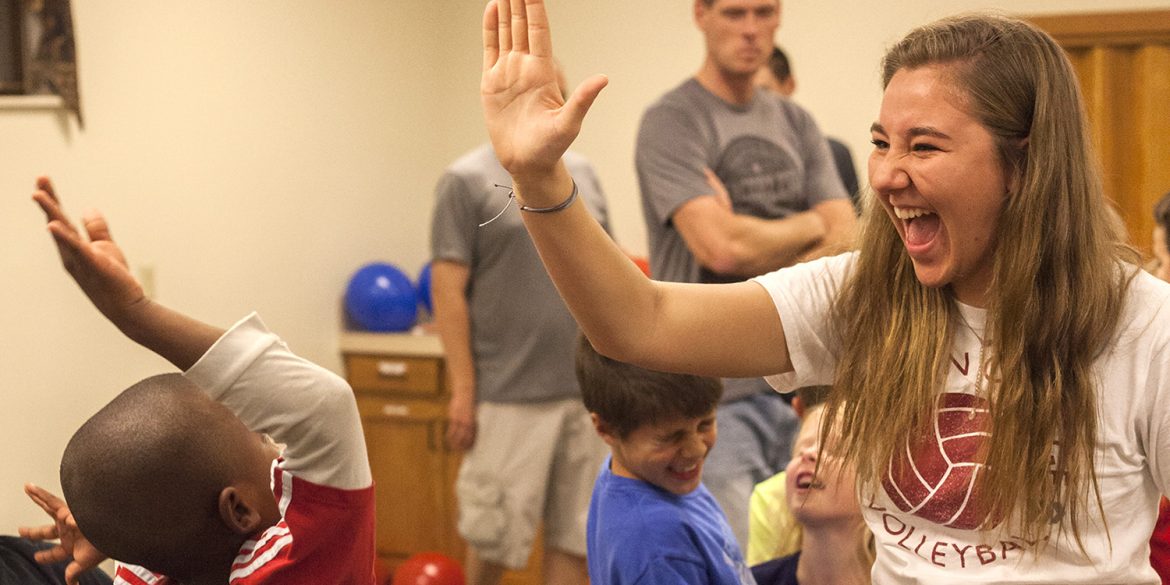 Freshman Cassidy King high fives a WOW participant during a game.