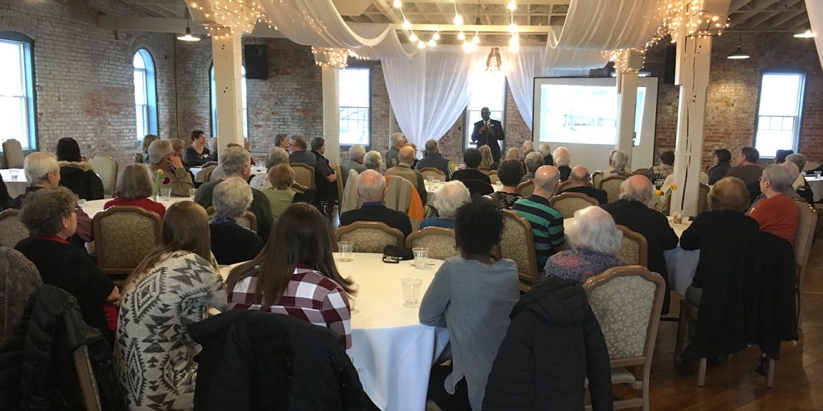 President Joe Manickam presents about current events at the college to a group of Hesston College alumni and friends at a gathering in Goshen, Ind.